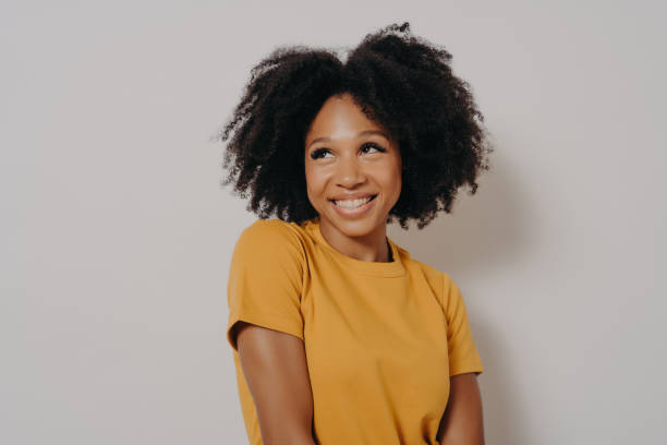 Studio shot close up portrait of casually dressed cute african american girl with funny astonished face expression. Emotional young mixed race woman with beautiful curly hair on white background